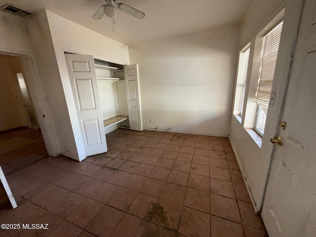 unfurnished bedroom with vaulted ceiling, a closet, and ceiling fan