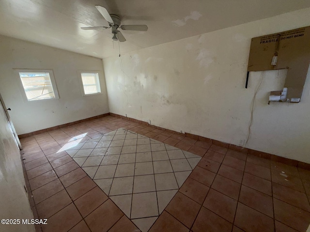 unfurnished room with lofted ceiling, ceiling fan, and light tile patterned flooring