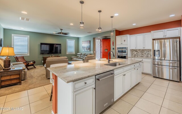 kitchen featuring visible vents, a sink, stainless steel appliances, light tile patterned floors, and ceiling fan