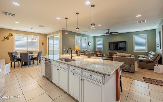 kitchen with light tile patterned flooring, visible vents, white cabinets, and a sink