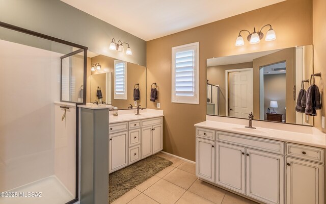bathroom with tile patterned floors, a shower stall, two vanities, and a sink