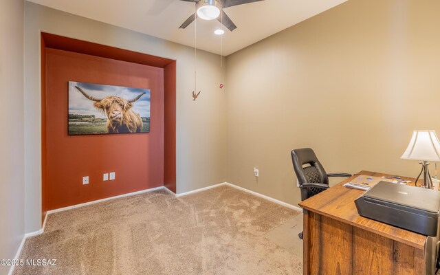 carpeted office space with baseboards and ceiling fan