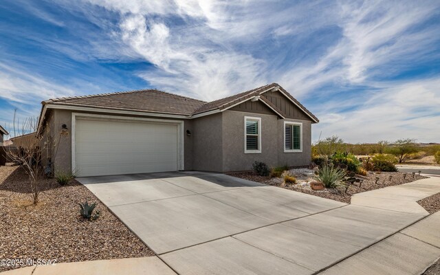 single story home featuring a tile roof, stucco siding, an attached garage, and concrete driveway