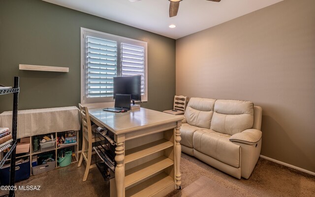 carpeted office with a ceiling fan and baseboards