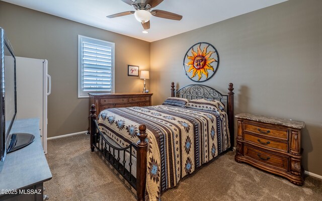 carpeted bedroom featuring baseboards and ceiling fan