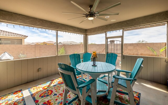 sunroom / solarium with outdoor dining area and ceiling fan