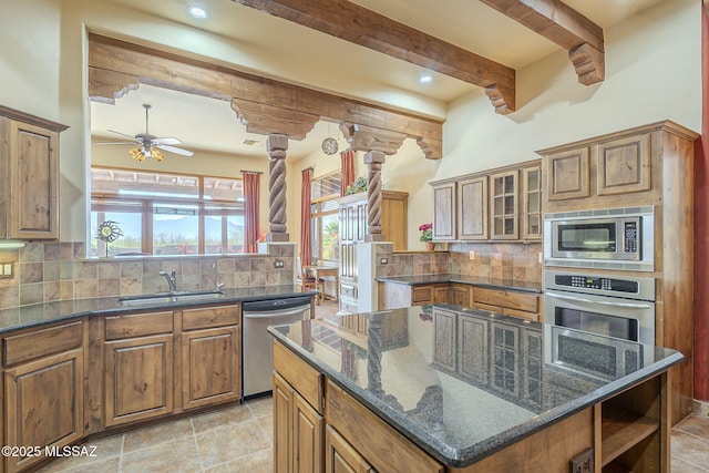 kitchen featuring stainless steel appliances, a sink, and brown cabinets