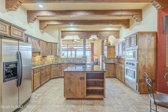 kitchen featuring a sink, a kitchen island, appliances with stainless steel finishes, open shelves, and dark countertops