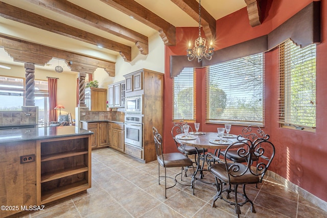 kitchen featuring stainless steel appliances, dark countertops, a chandelier, and a wealth of natural light