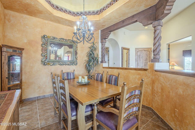 tiled dining room with a chandelier and baseboards