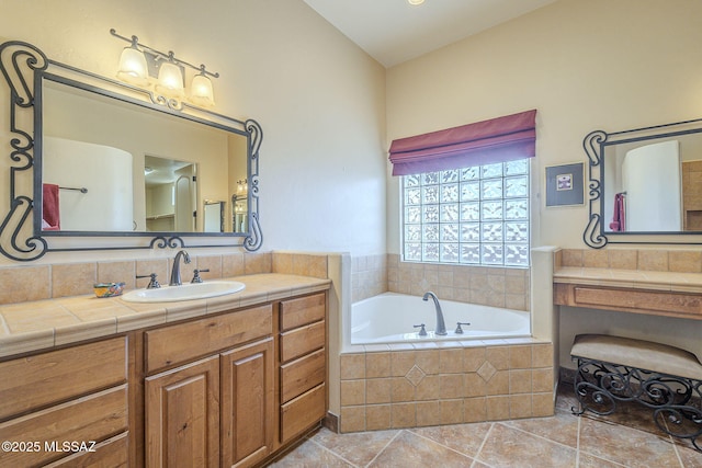 bathroom with tile patterned flooring, a garden tub, and vanity