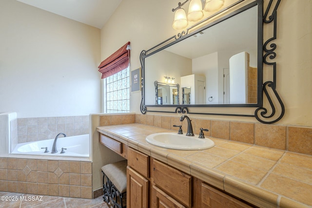 bathroom featuring tiled tub, visible vents, tile patterned flooring, and vanity