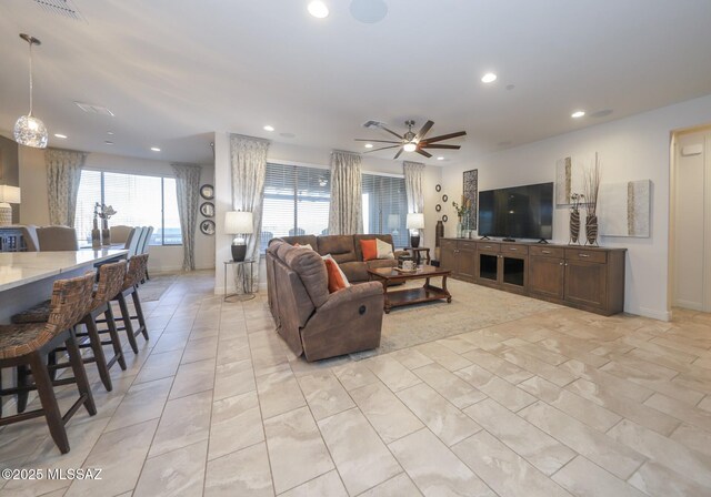 living room featuring a ceiling fan, recessed lighting, visible vents, and baseboards