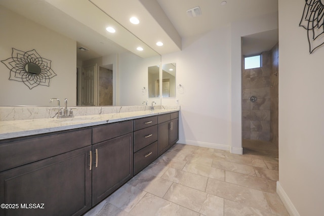 bathroom featuring a sink, baseboards, and double vanity