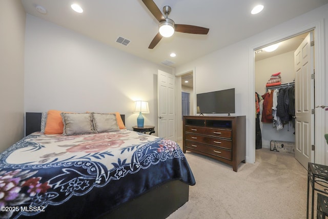 bedroom featuring visible vents, light colored carpet, a walk in closet, a closet, and recessed lighting