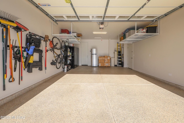 garage featuring freestanding refrigerator and a garage door opener