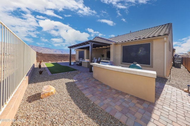 view of patio with an outdoor living space, cooling unit, a fenced backyard, and a mountain view