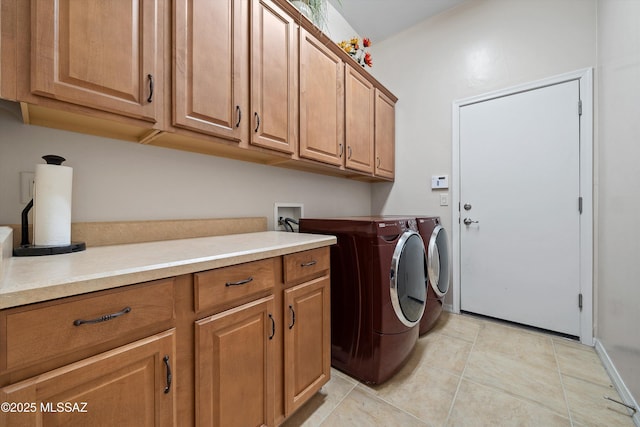 washroom featuring light tile patterned flooring, cabinets, and washer and clothes dryer