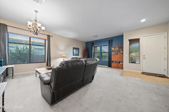 carpeted living room with a chandelier