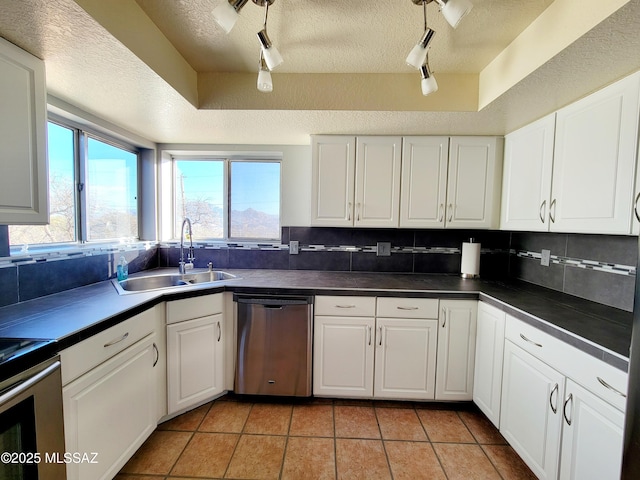 kitchen with white cabinets, dishwasher, a textured ceiling, and sink