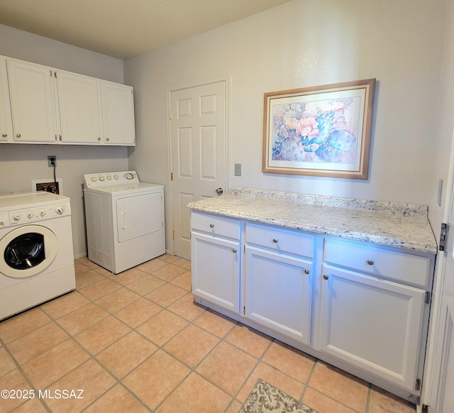 washroom featuring cabinets, light tile patterned floors, and washer and clothes dryer