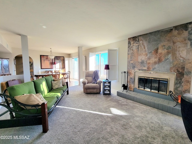 living room with carpet flooring and a tiled fireplace