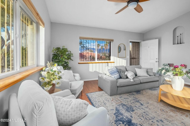 living room featuring wood-type flooring, ceiling fan, and vaulted ceiling