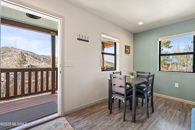 dining room with recessed lighting, wood finished floors, a mountain view, and baseboards