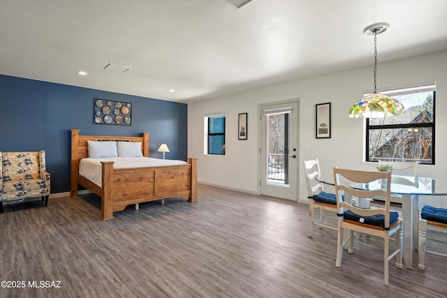 bedroom with access to outside, multiple windows, and wood finished floors