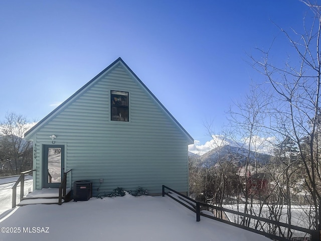 view of snow covered exterior with a mountain view and central AC
