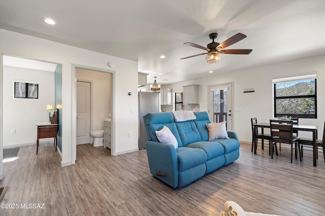 living room with baseboards, wood finished floors, and recessed lighting