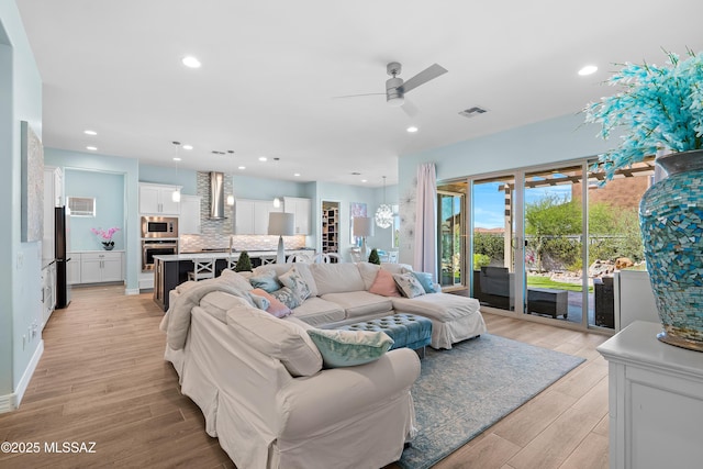 living room featuring ceiling fan and light hardwood / wood-style flooring