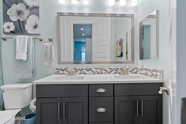 bathroom with vanity, backsplash, and toilet