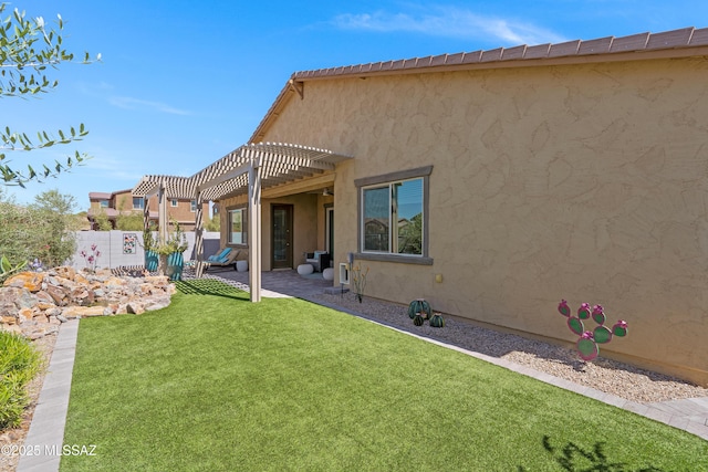 rear view of house featuring a patio, a lawn, and a pergola