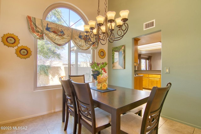 dining room featuring light tile patterned floors, baseboards, visible vents, and a chandelier