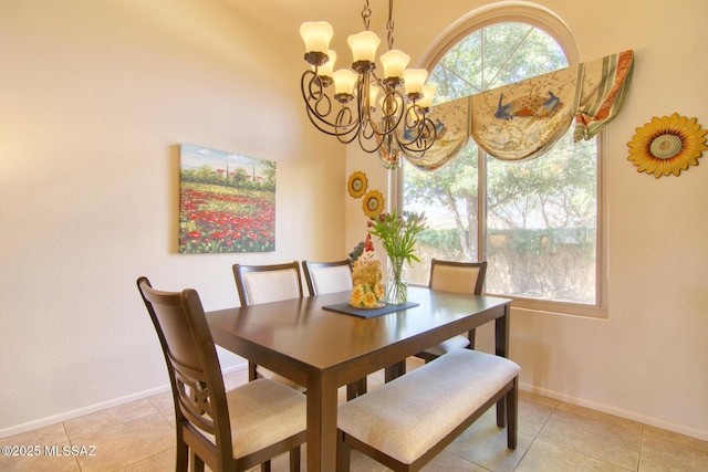 dining area with light tile patterned floors, baseboards, and a chandelier