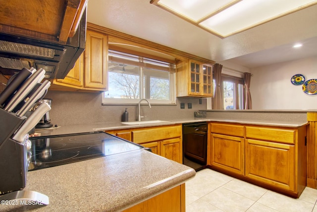 kitchen featuring light countertops, light tile patterned flooring, a sink, dishwasher, and a peninsula