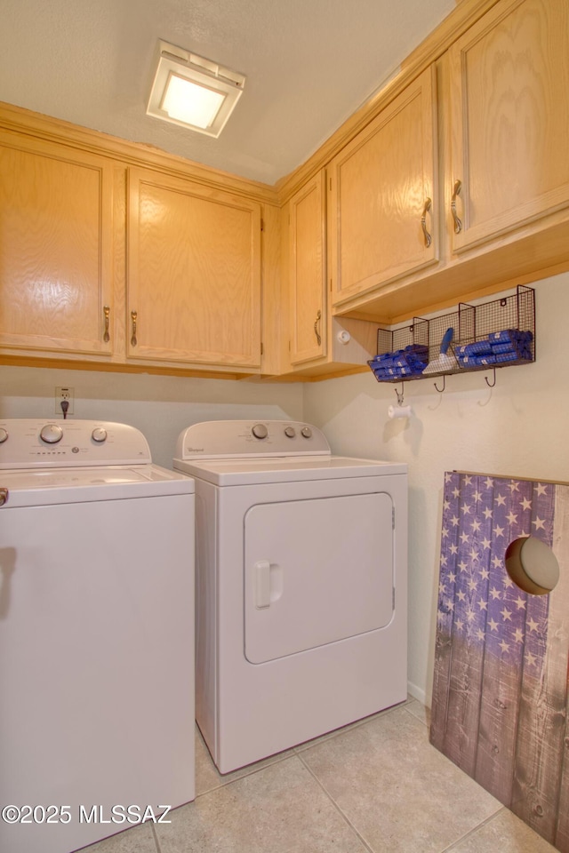 washroom with light tile patterned floors, cabinet space, and separate washer and dryer