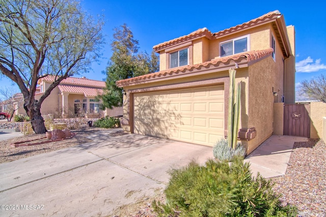 mediterranean / spanish house with a garage, a tile roof, concrete driveway, and stucco siding