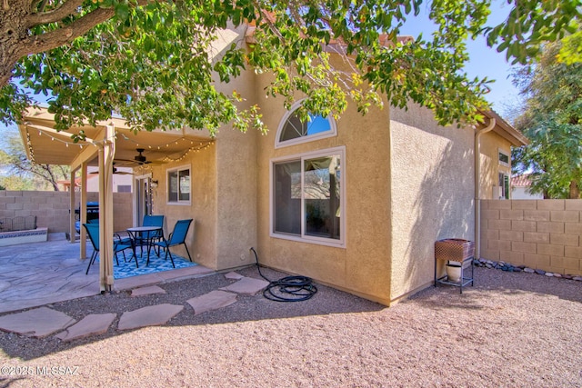 back of house featuring ceiling fan, a patio area, fence, and stucco siding