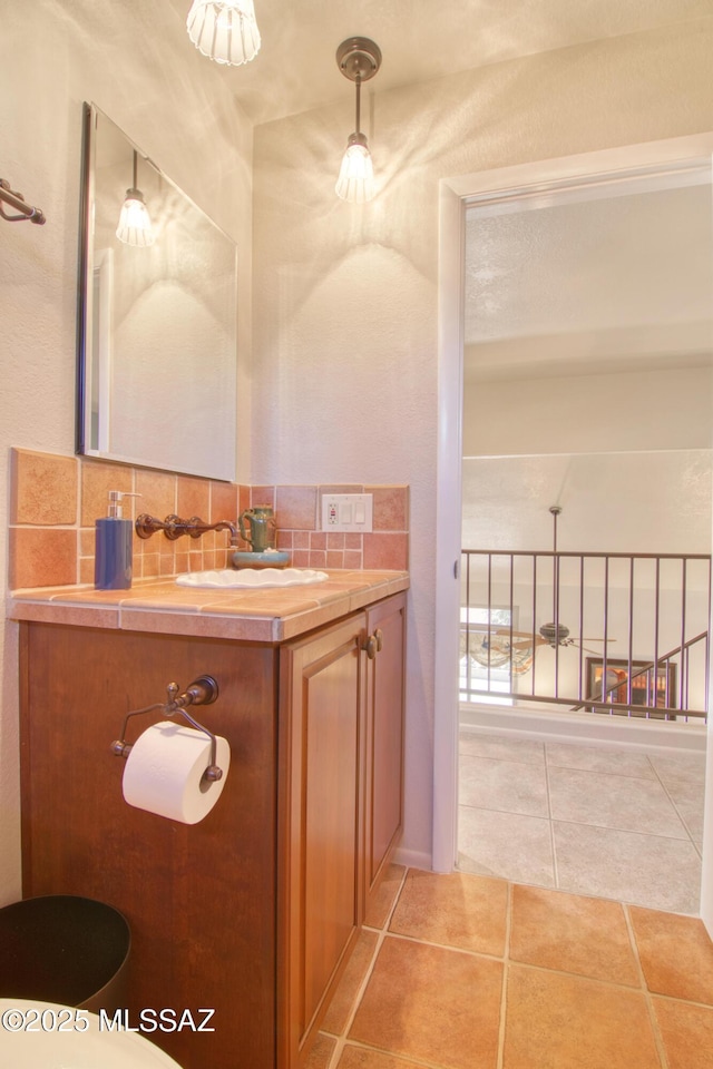 bathroom with tasteful backsplash, vanity, and tile patterned floors