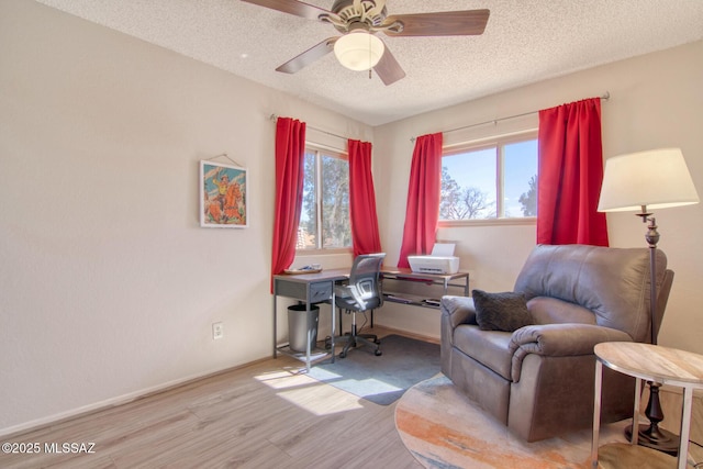 sitting room featuring a textured ceiling, wood finished floors, a ceiling fan, and baseboards