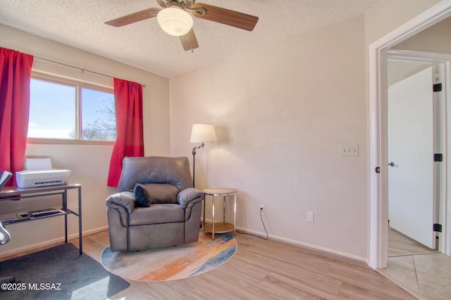 sitting room with a textured ceiling, wood finished floors, and a ceiling fan