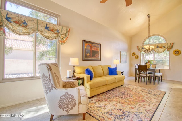 living room with ceiling fan with notable chandelier, high vaulted ceiling, tile patterned flooring, and baseboards