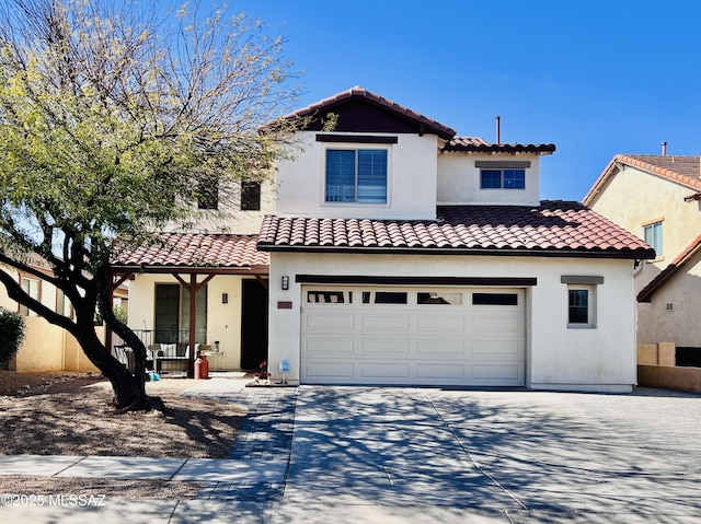 mediterranean / spanish home featuring a garage, concrete driveway, a tile roof, and stucco siding