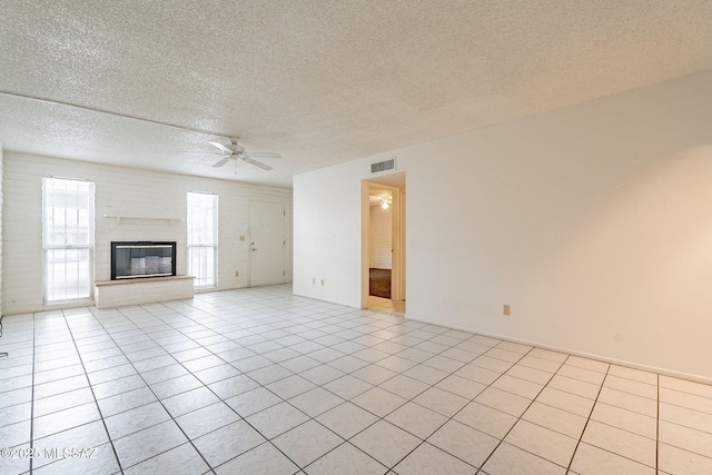 unfurnished living room with a textured ceiling, ceiling fan, and light tile patterned flooring