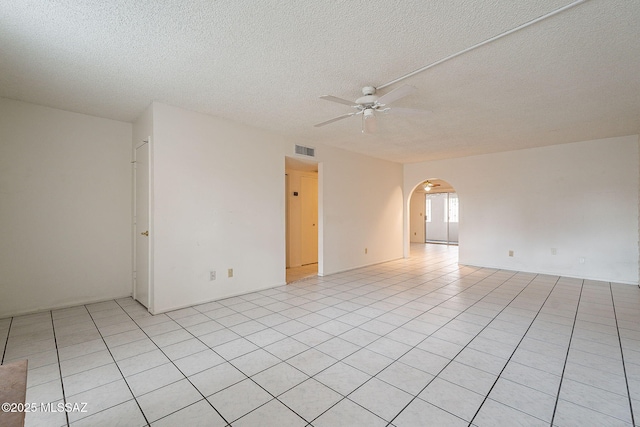 tiled spare room featuring a textured ceiling and ceiling fan