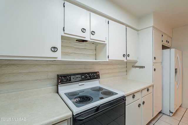 kitchen with white cabinetry, white refrigerator with ice dispenser, electric range oven, and light tile patterned floors