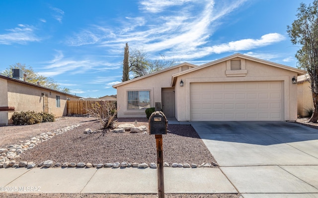 view of front of house featuring driveway, a garage, fence, and stucco siding