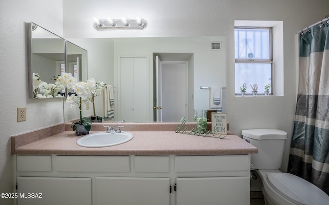 full bathroom featuring visible vents, vanity, and toilet